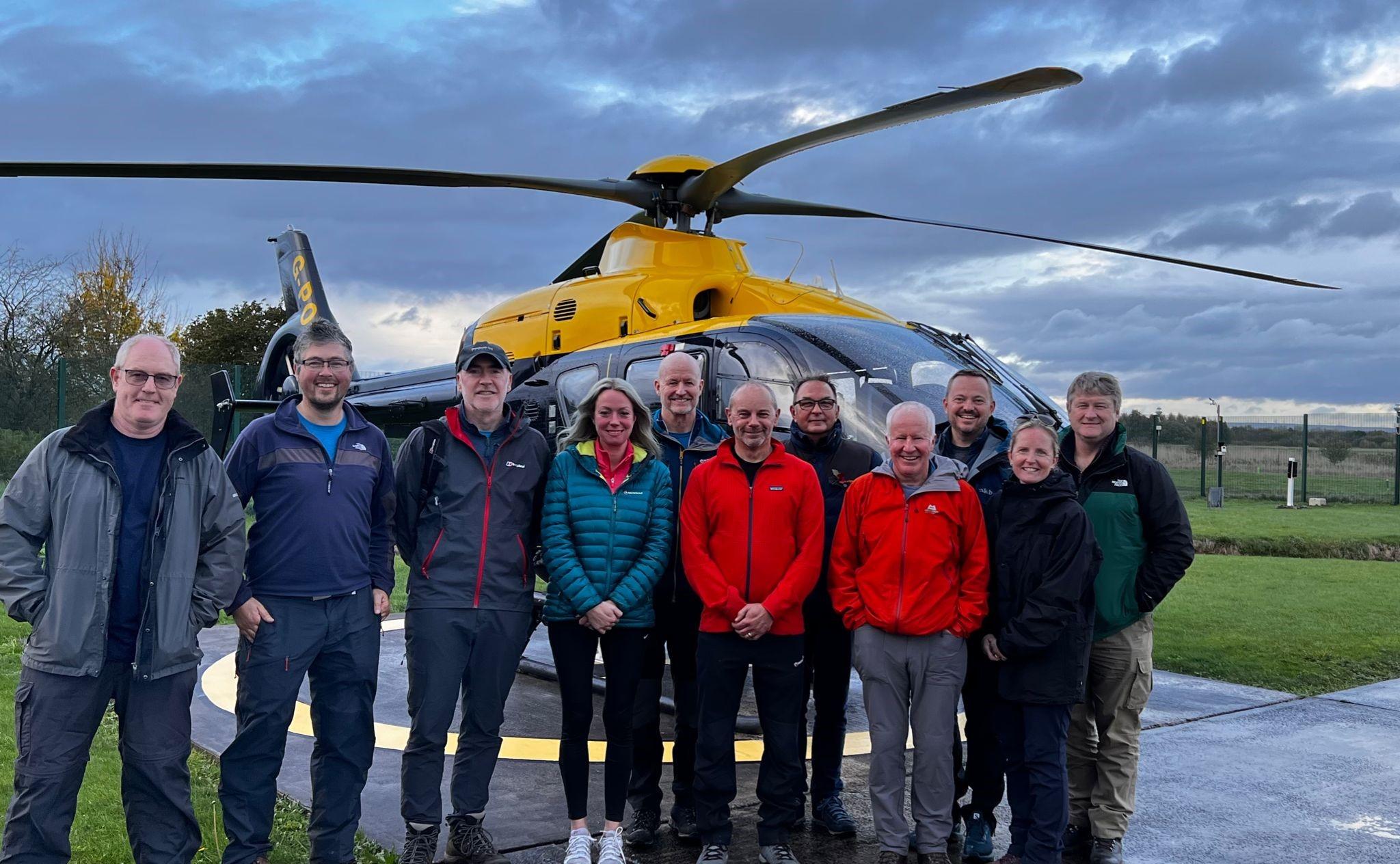 A NPAS North West team of staff standing in front of the NPAS Barton police helicopter