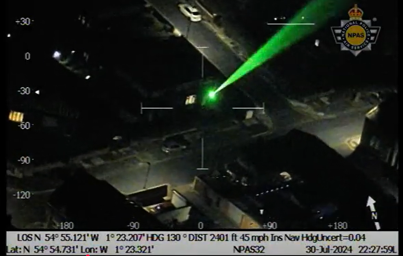 Green laser being shone into darkness