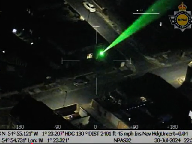 Green laser being shone into darkness